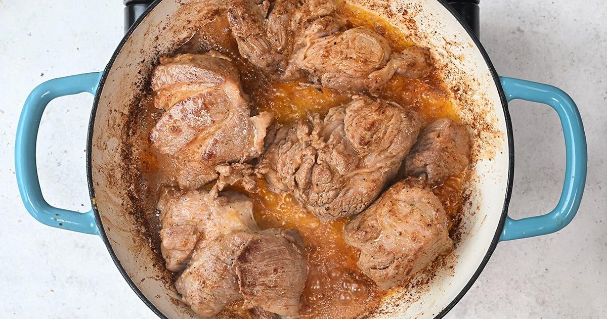 searing pork shoulder in a casserole dish