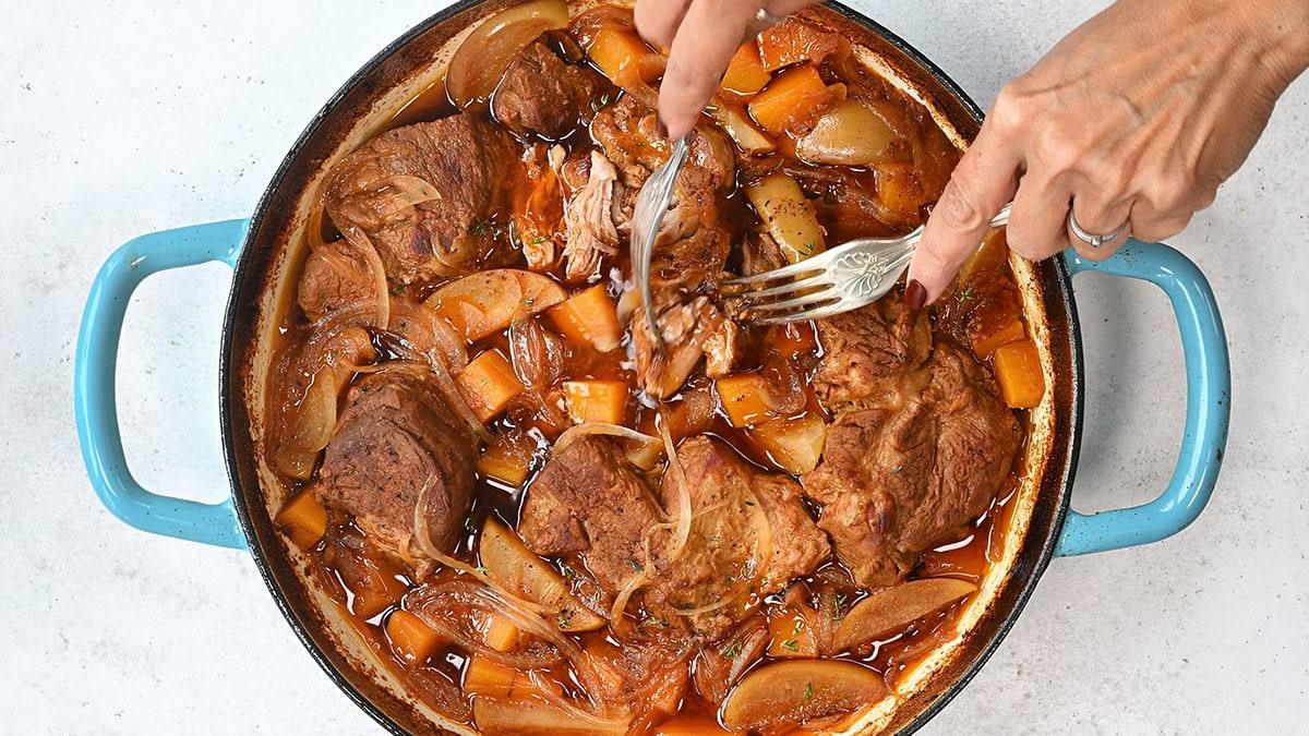 braised pork with apples and butternut squash in a casserole dish
