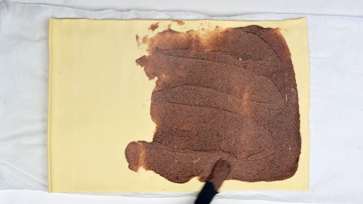 spreading cinnamon filling over puff pastry