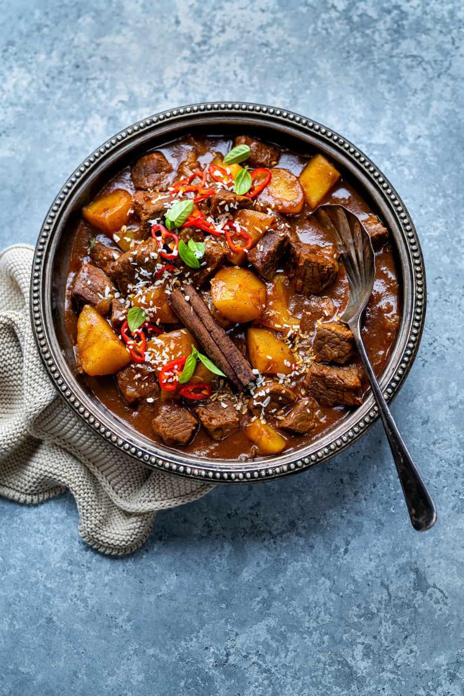 Thai beef curry shown overhead served in an ornate bowl