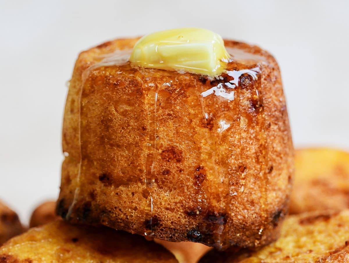 cornbread muffin topped with butter and honey (close up)