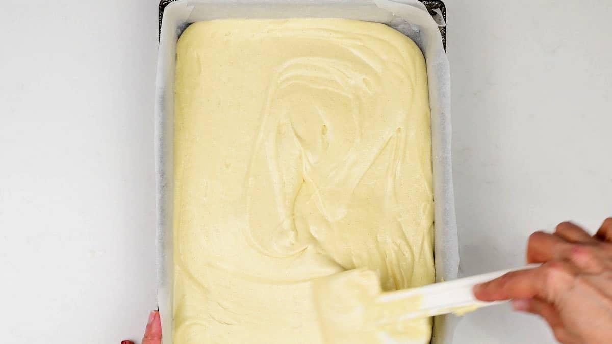 spreading cake batter into a rectangular cake pan