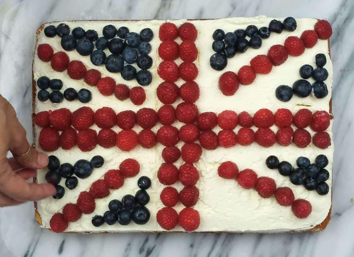 decorating a Coronation Cake with fresh berries