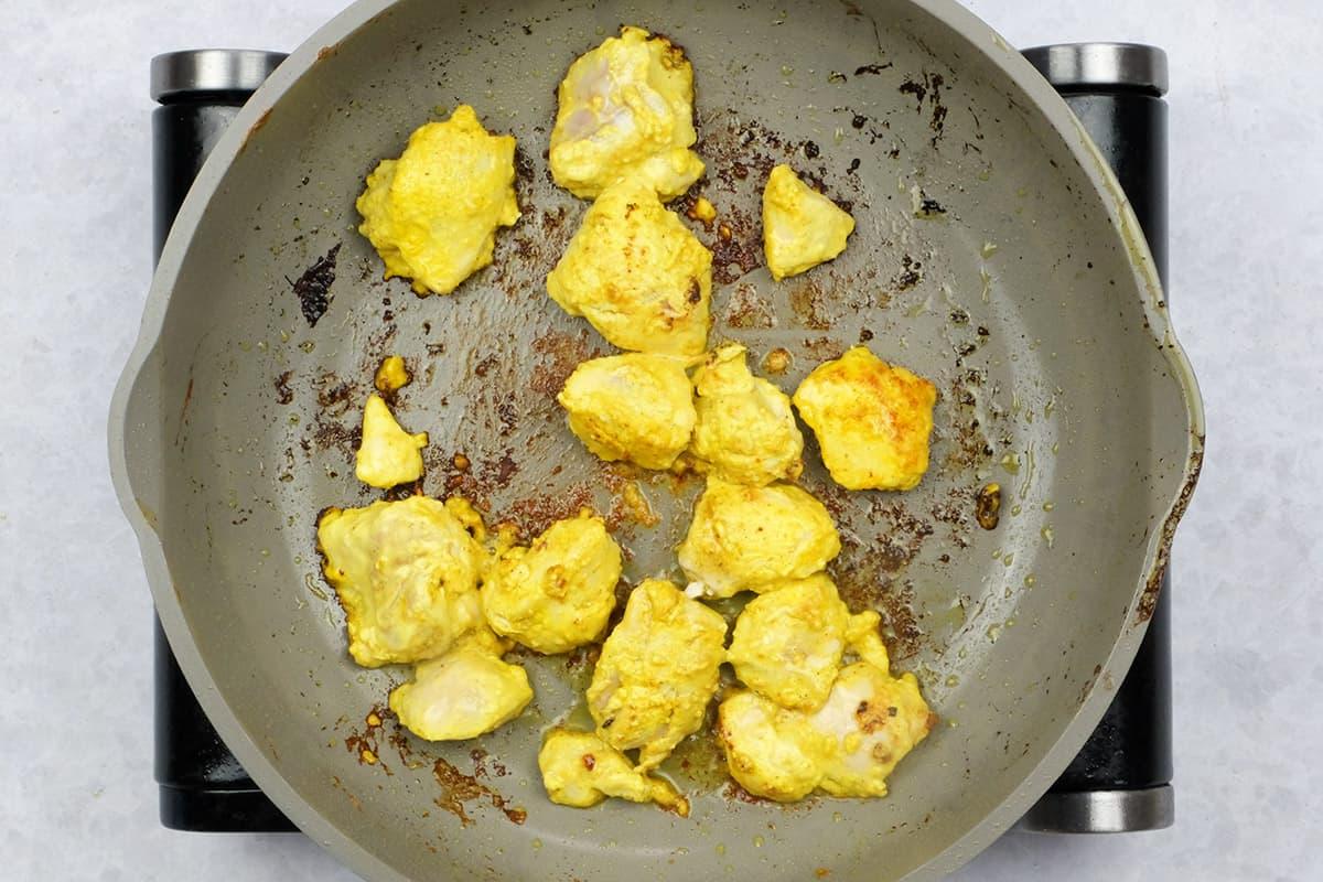 Searing chicken pieces in a pan