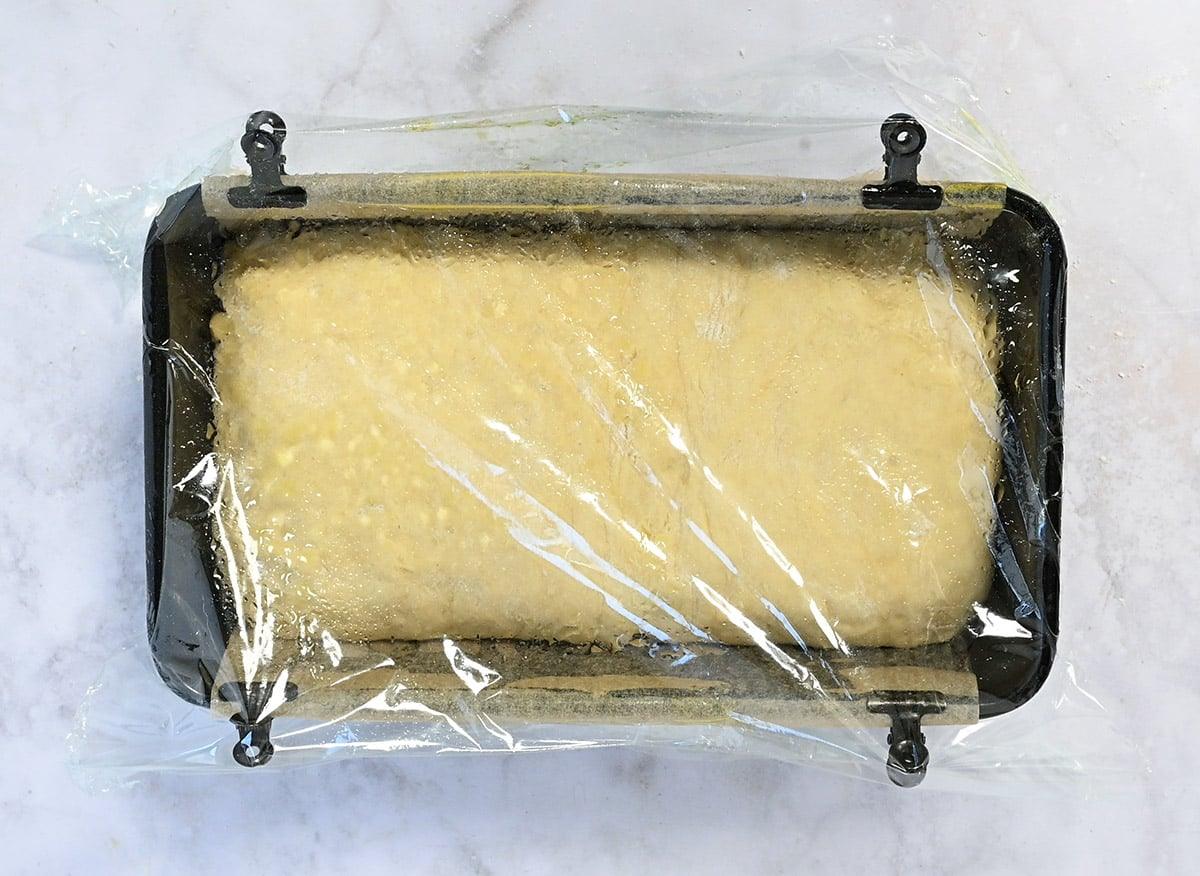 loaf of cottacge cheese bread proving in a loaf pan
