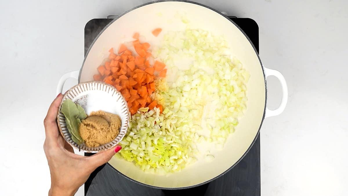 Cooking onions, carrots and celery in a large casserole dish for Slimming World Cottage Pie