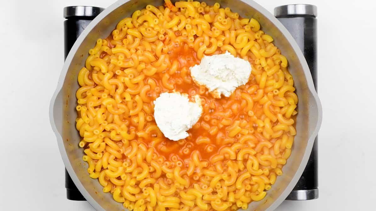 stirring cream cheese into pasta
