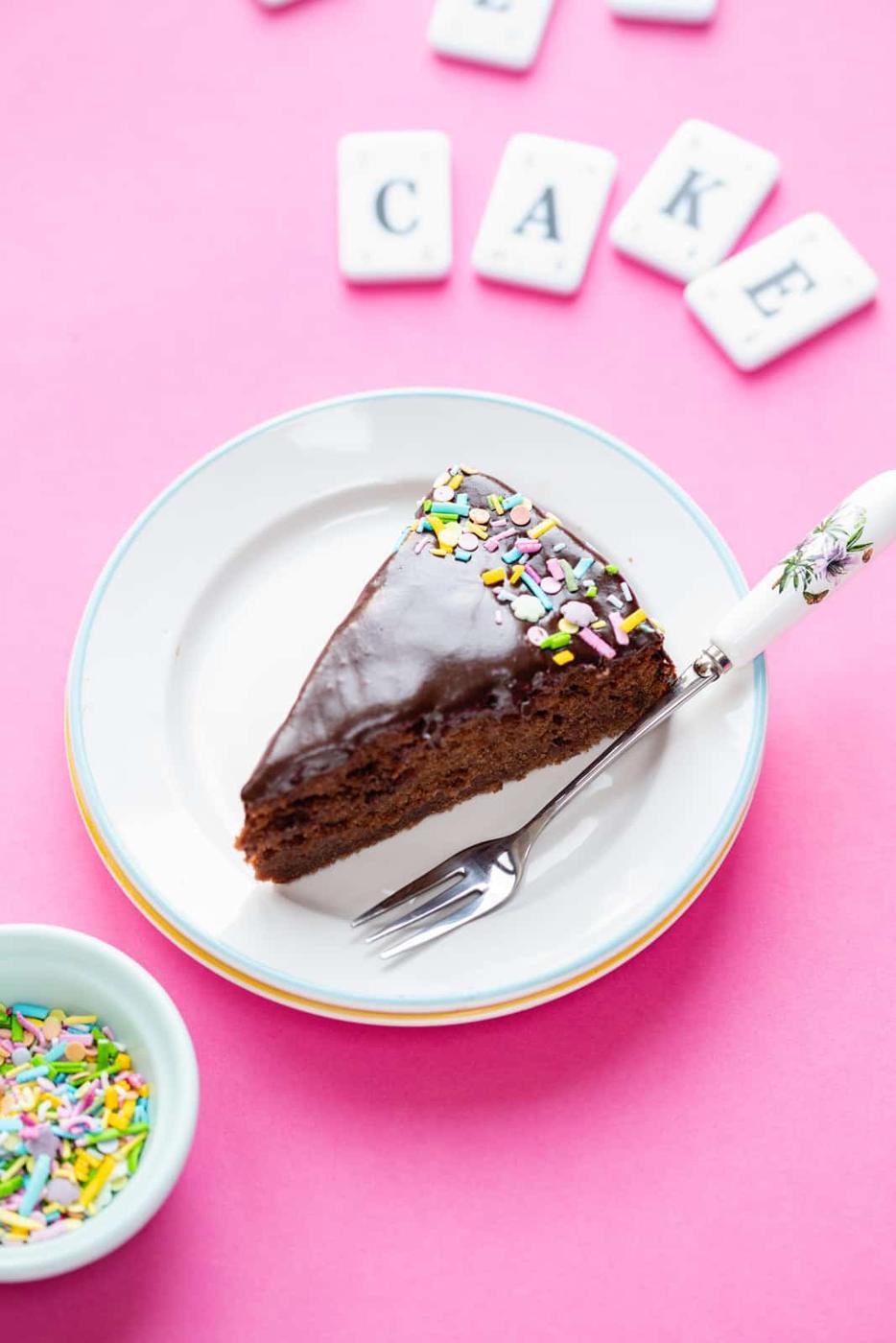 slice of chocolate crazy cake on a small plate with fork on side