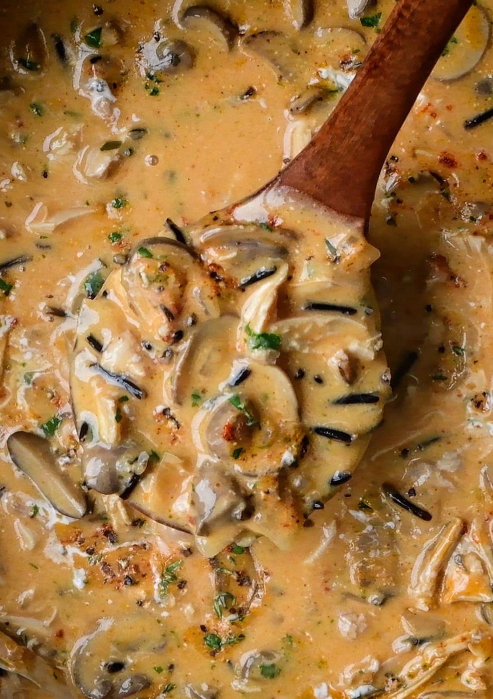 close up on a ladle of chicken and wild rice soup