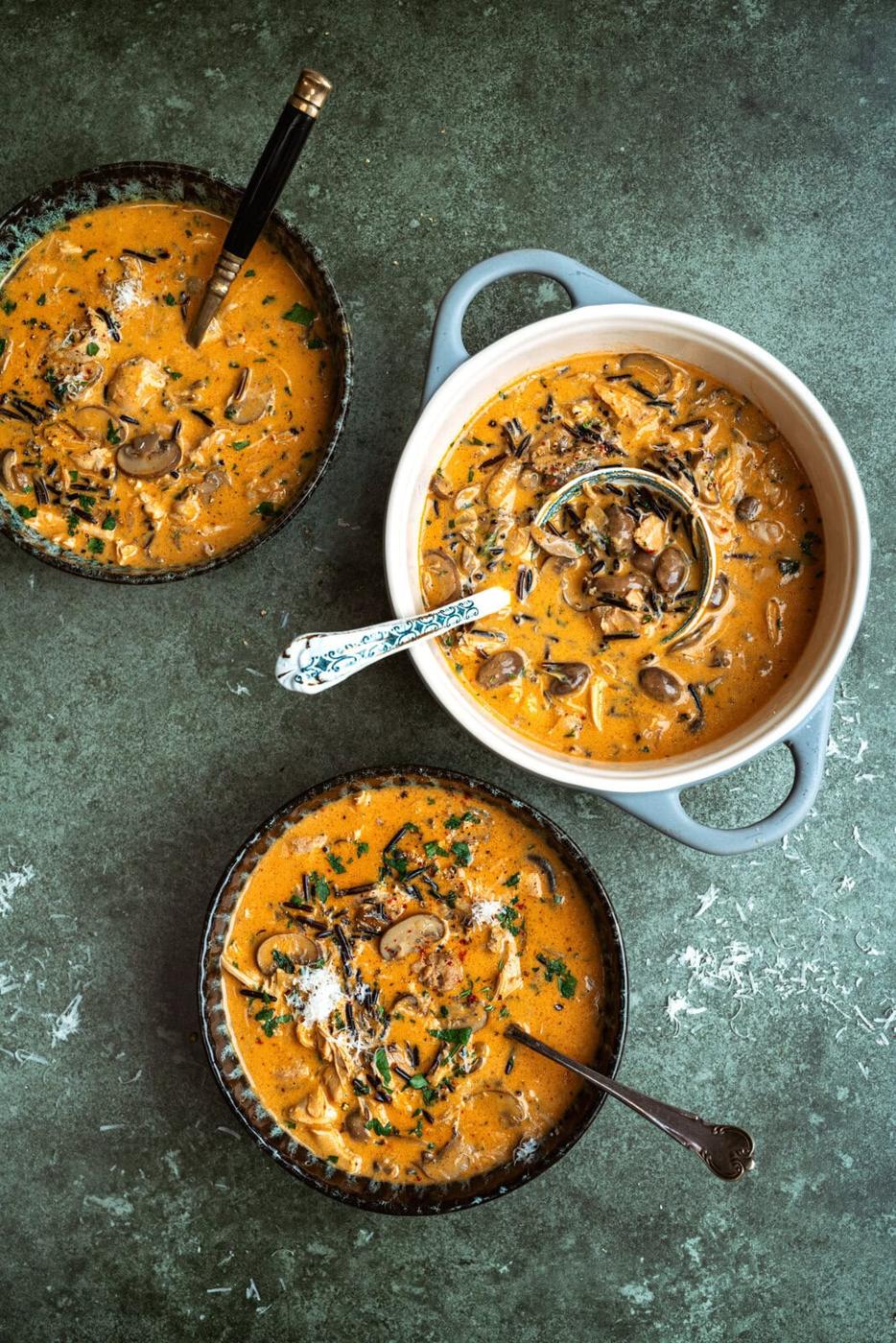 Creamy Chicken and Wild Rice Soup, two small bowls and a pot on a green background