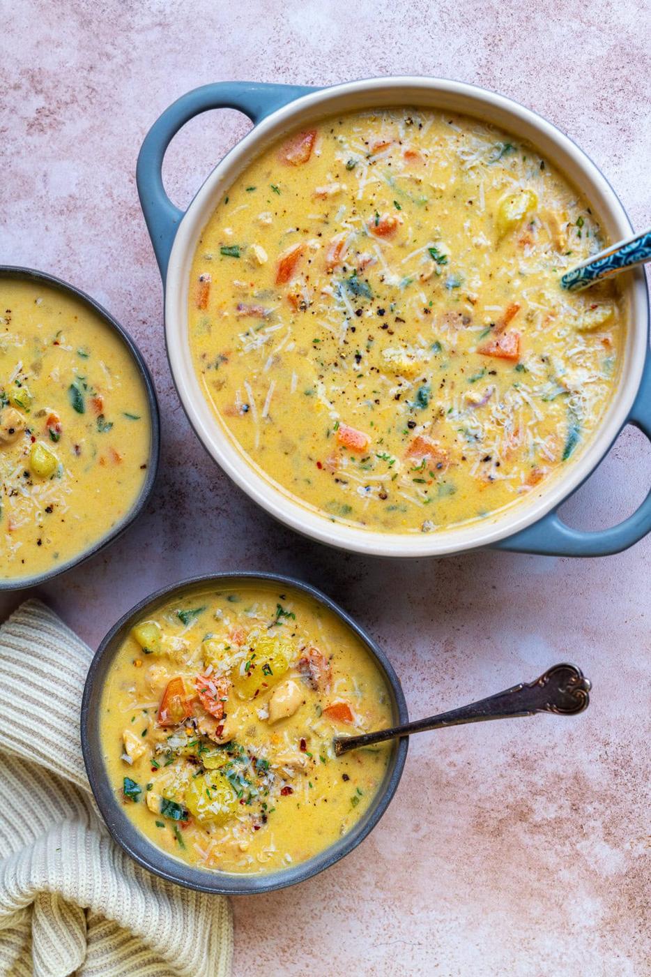 hearty chicken and potato soup, two bowls and a small pot