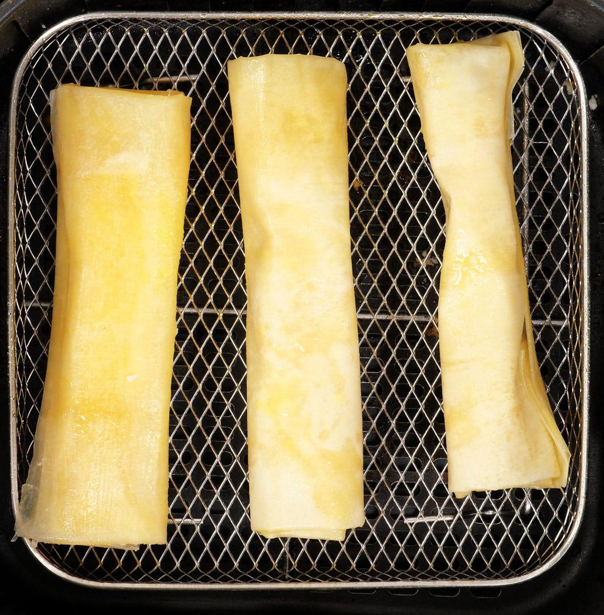 feta rolls in the basket of an air fryer
