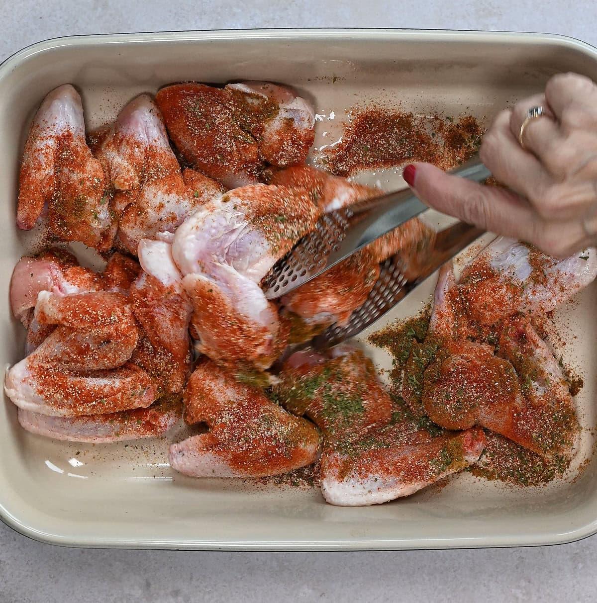 tossing chicken wings in seasonings prior to cooking