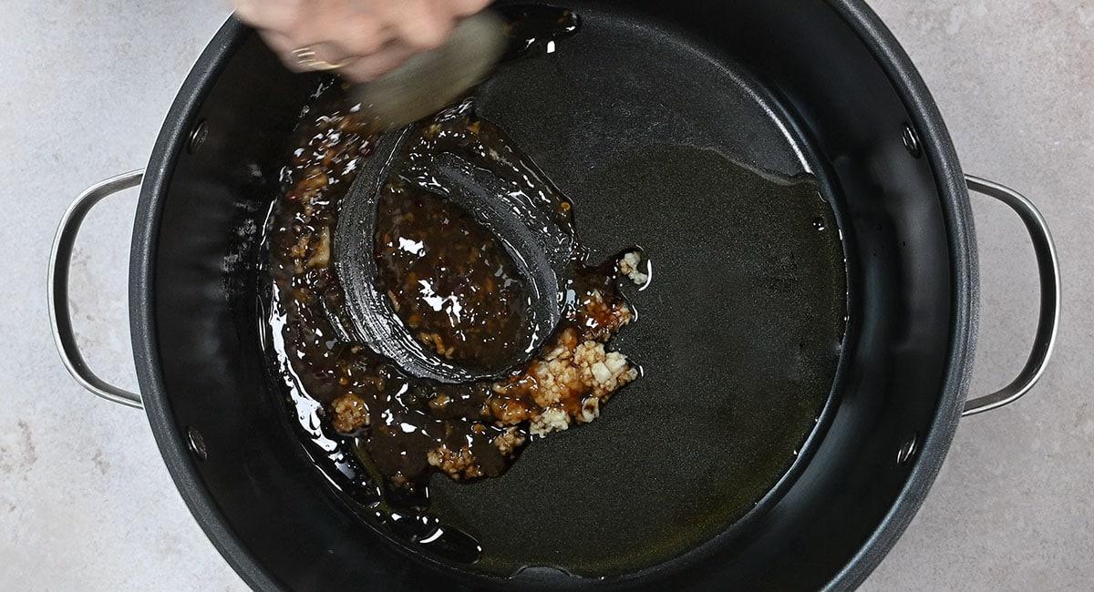 adding ingredients for chicken wings to slow cooker
