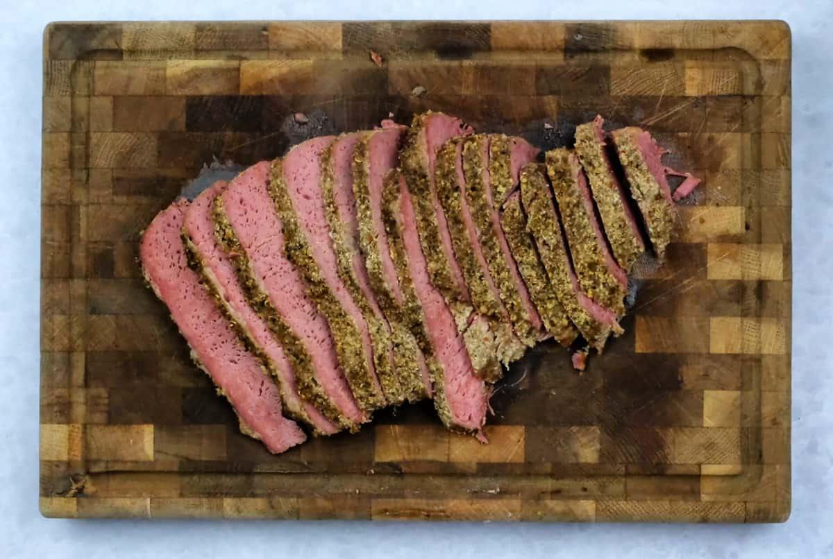 sliced corned beef brisket on a wooden butcher's block