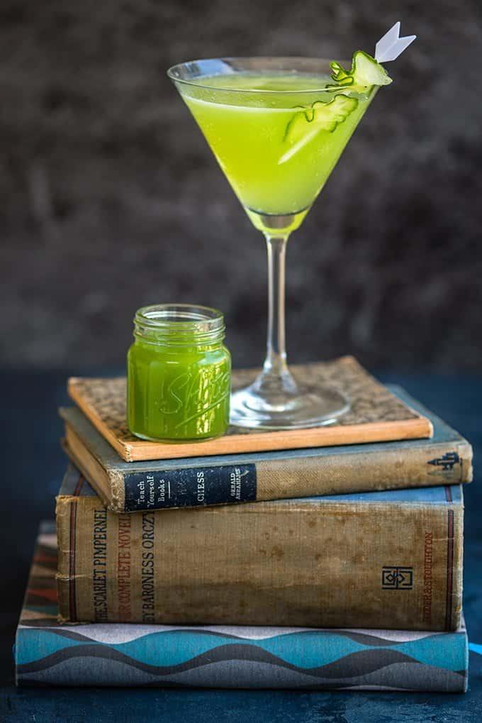 Cucumber martini with cucumber garnish in a martini glass with shot of cucumber juice on the side