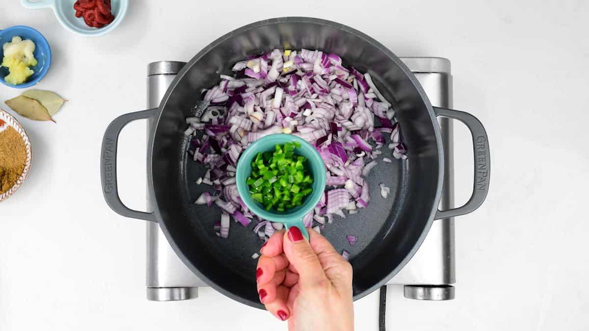 Cooking onion and green chilli in a pot