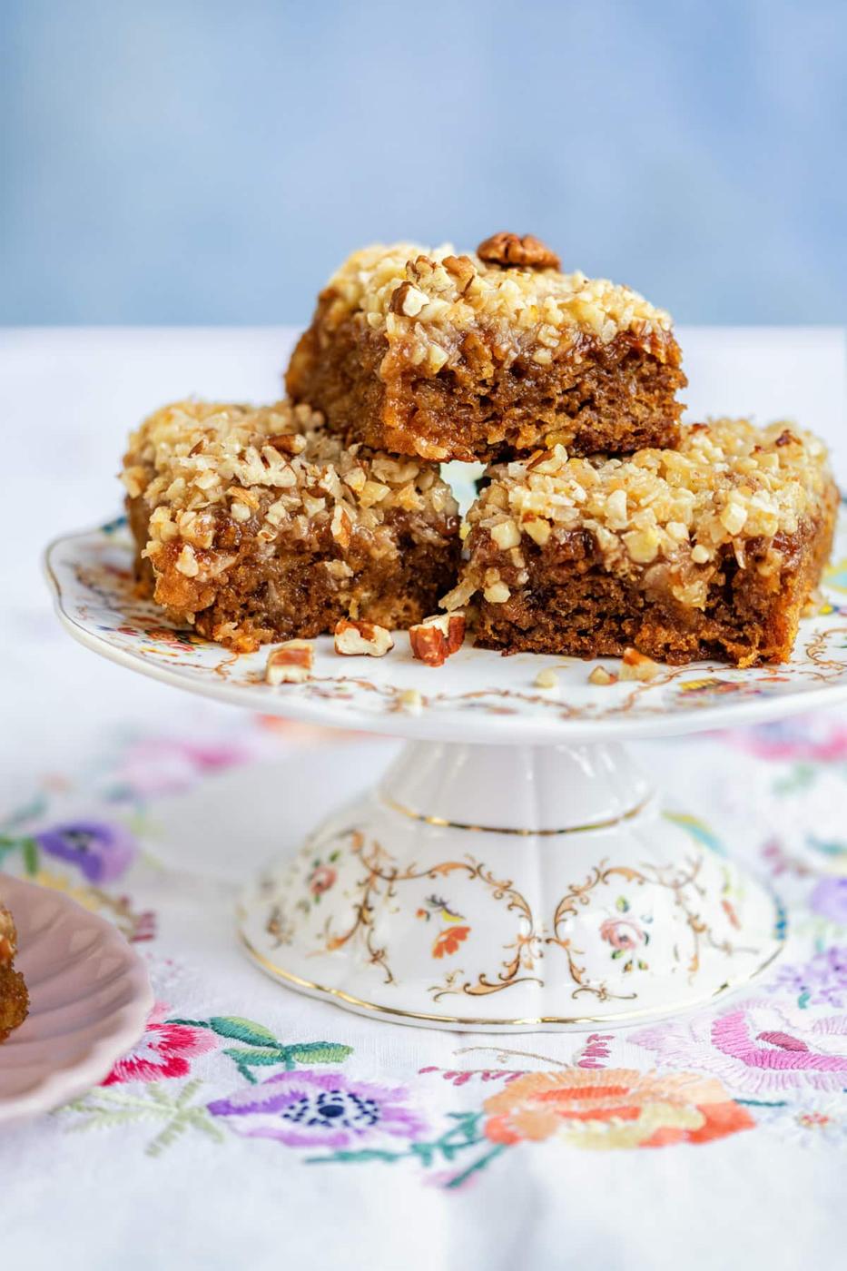 Slices of pineapple cake with coconut frosting on a cake stand