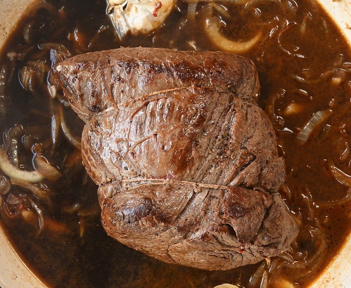Beef with onions in broth in a Dutch oven casserole
