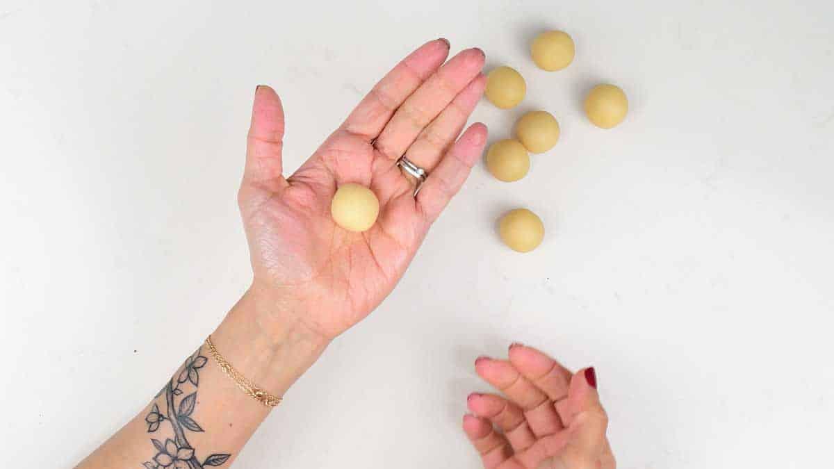 Rolling marzipan into small balls to decorate an Easter Simnel Cake