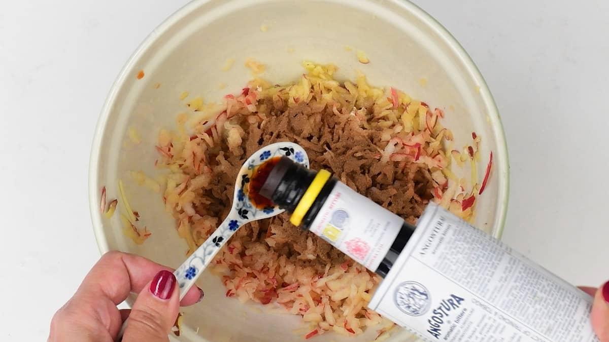 adding Angostura bitters to grated apple