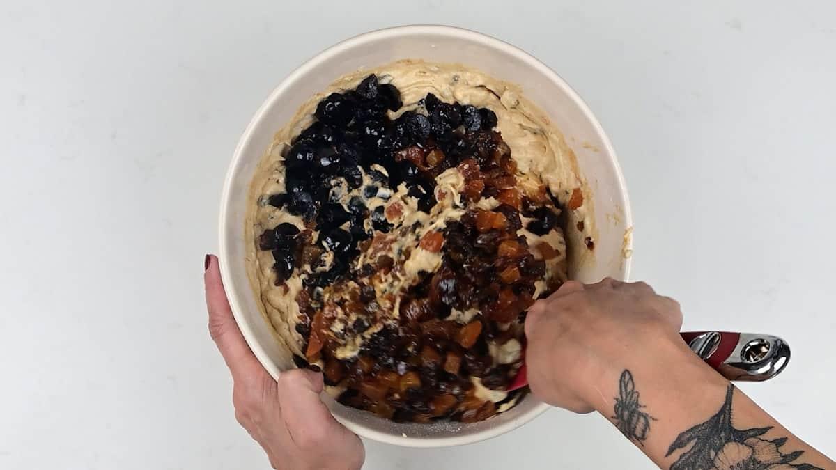 folding dried fruit into fruitcake batter