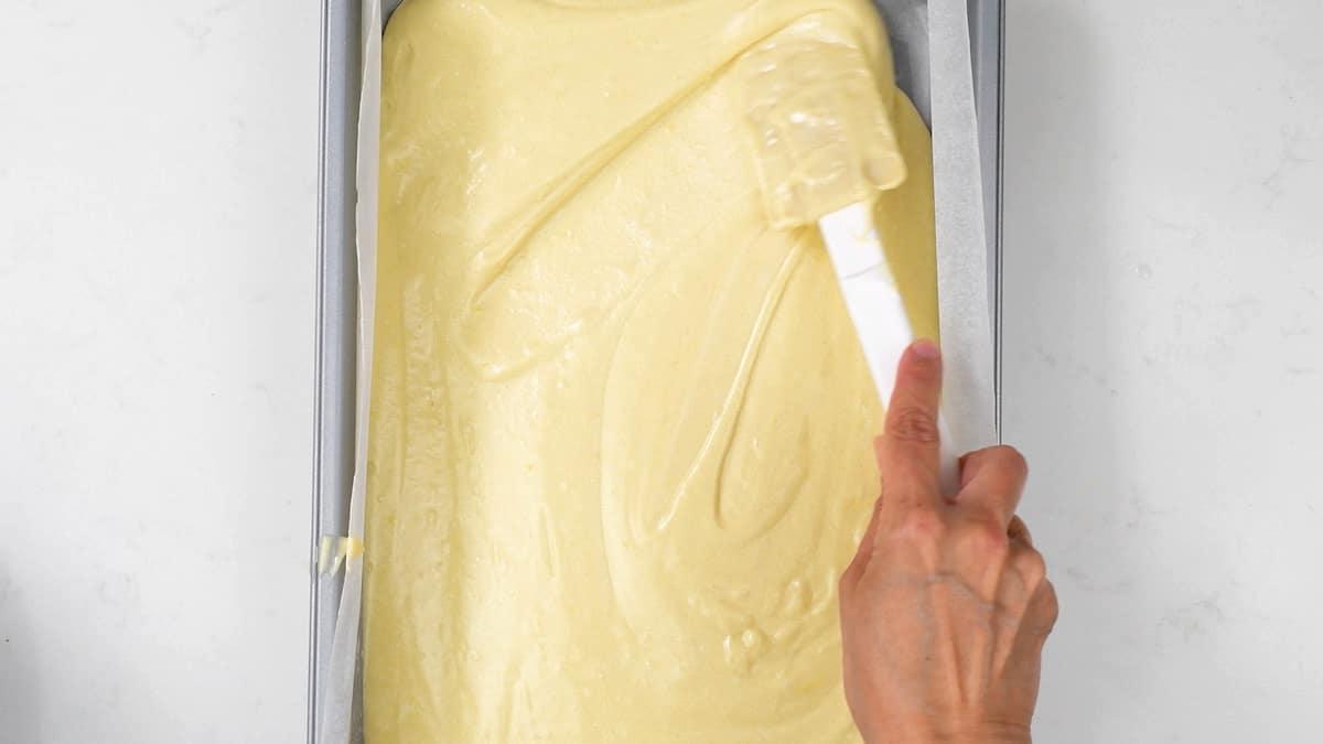 Spreading cake batter into lined rectangular cake tin