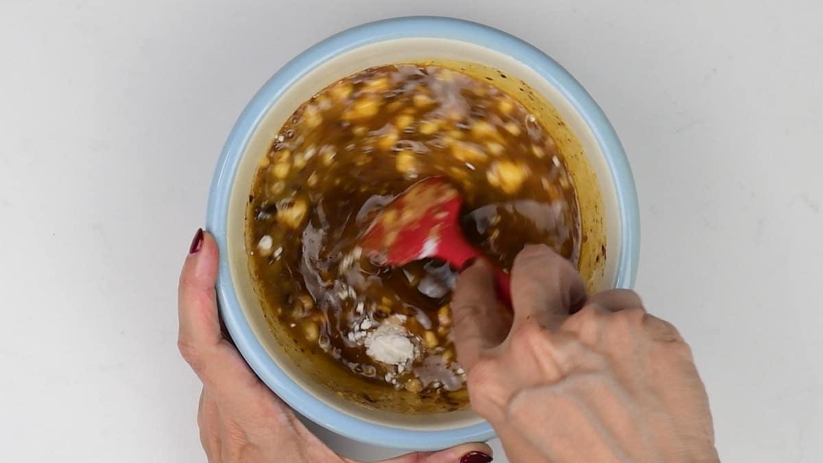 Stirring melted butter, ground cinnamon, flour and brown sugar in a bowl