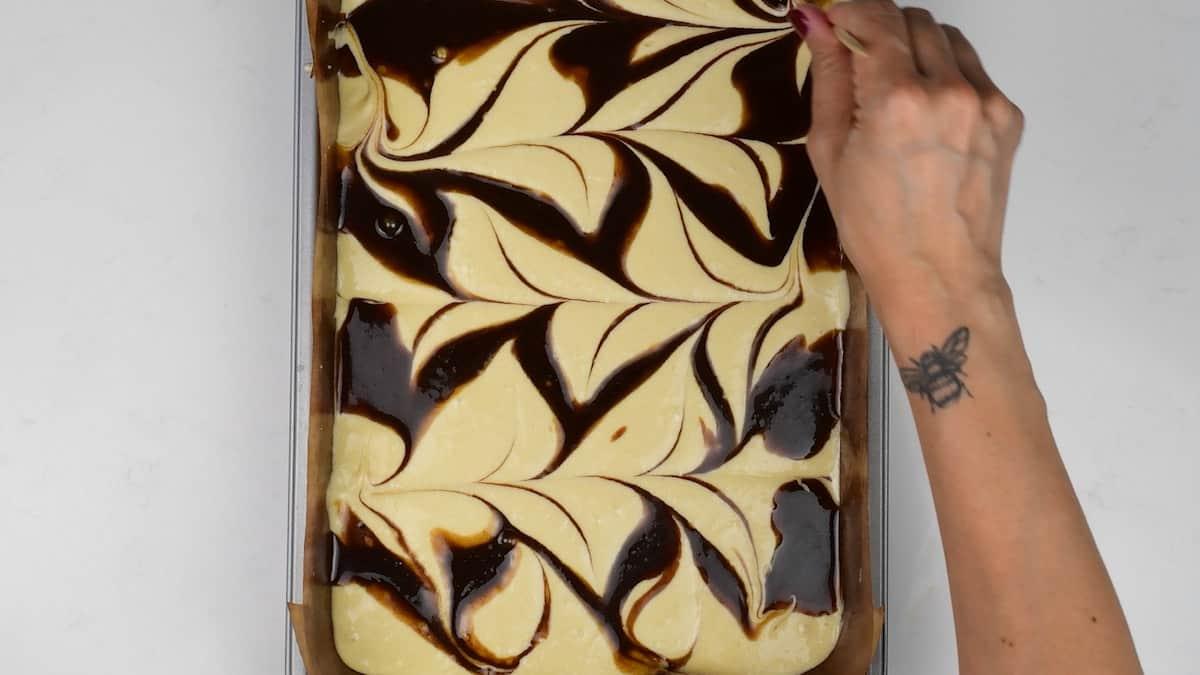 feathering cinnamon butter through cake batter for cinnamon roll cake