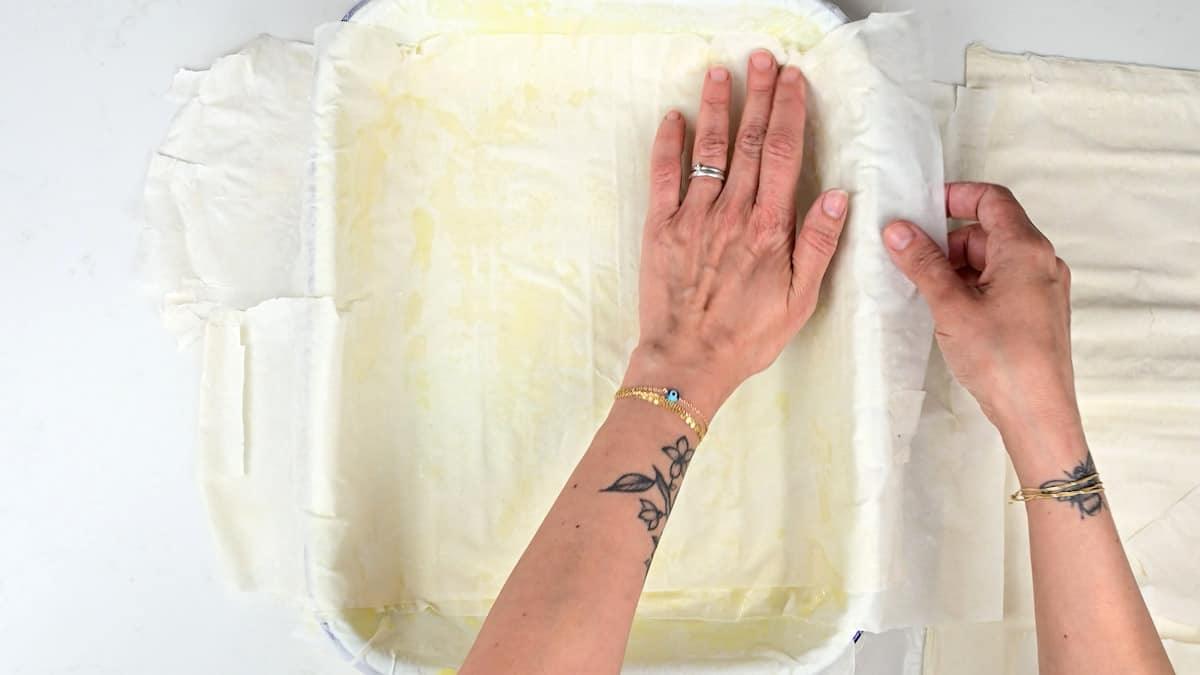 Layering filo pastry in a roasting tin