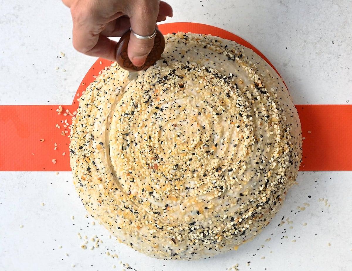 scoring the top of a sourdough loaf prior to baking