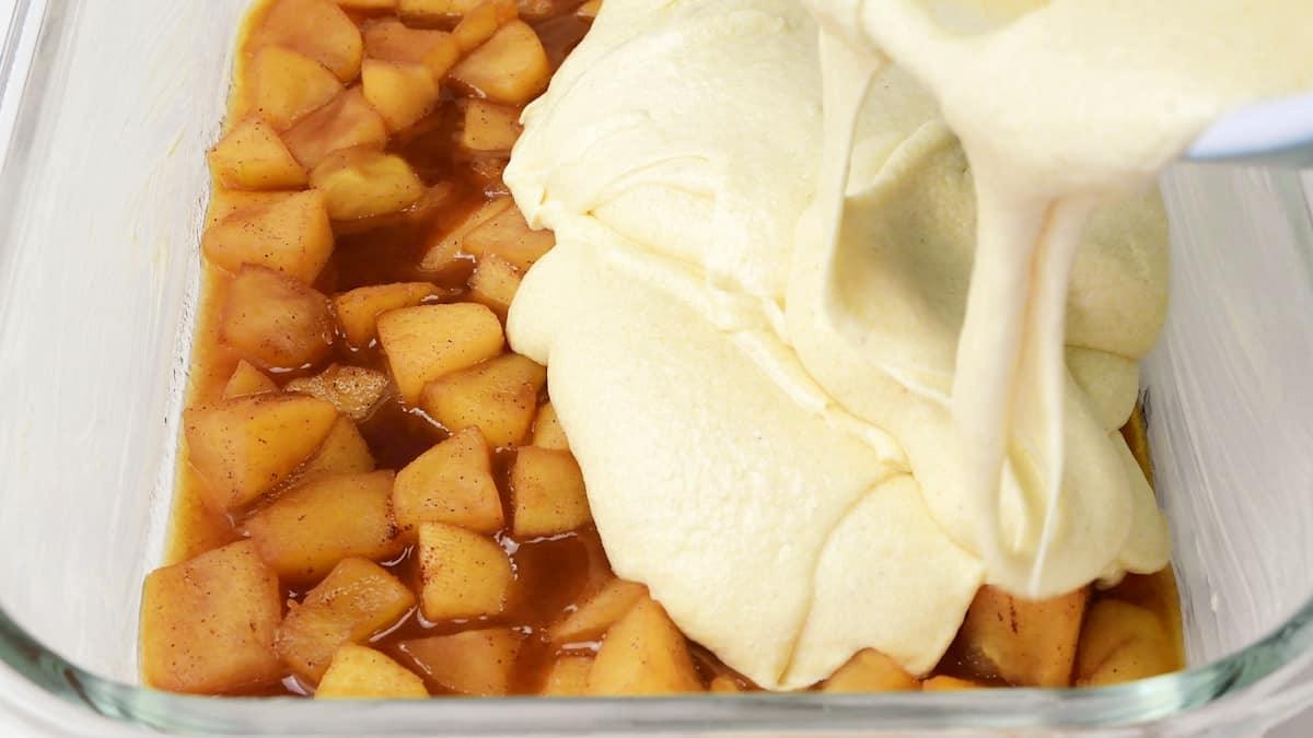 Spreading cake batter over stewed apples