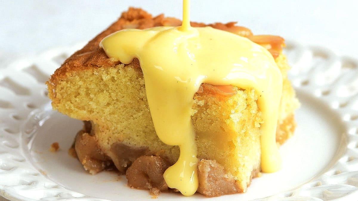 Serving of Eve's pudding with vanilla custard on a plate