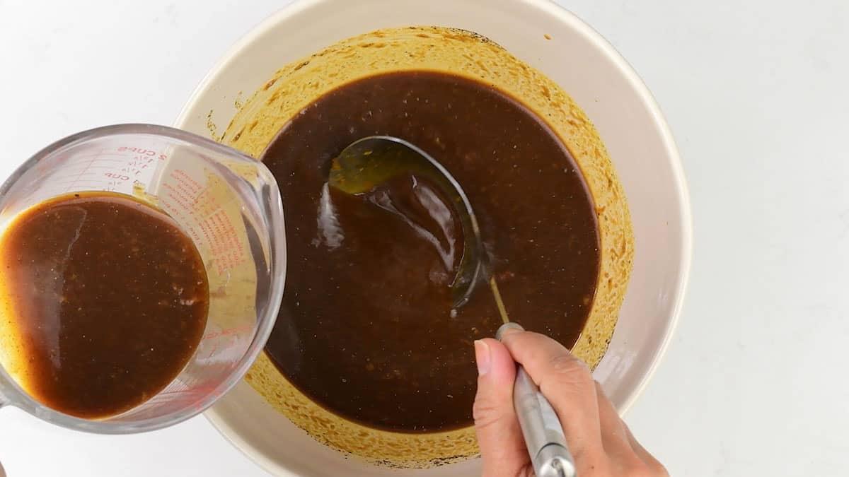 transferring part of the BBQ sauce to a measuring jug to reserve for later