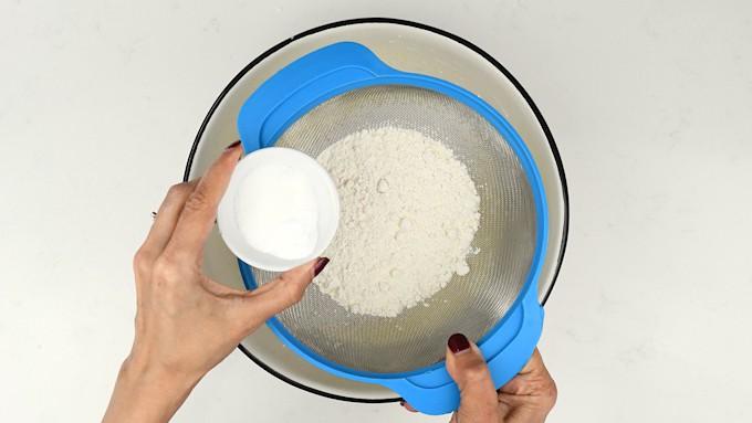 sifting dry ingredients into pancake batter