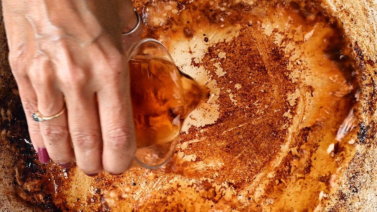 adding wine to hot pan to deglaze