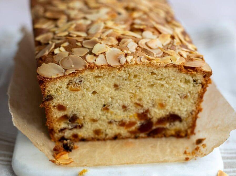 Loaf cake with dried fruit, cherries and almonds, slice cut to show interior