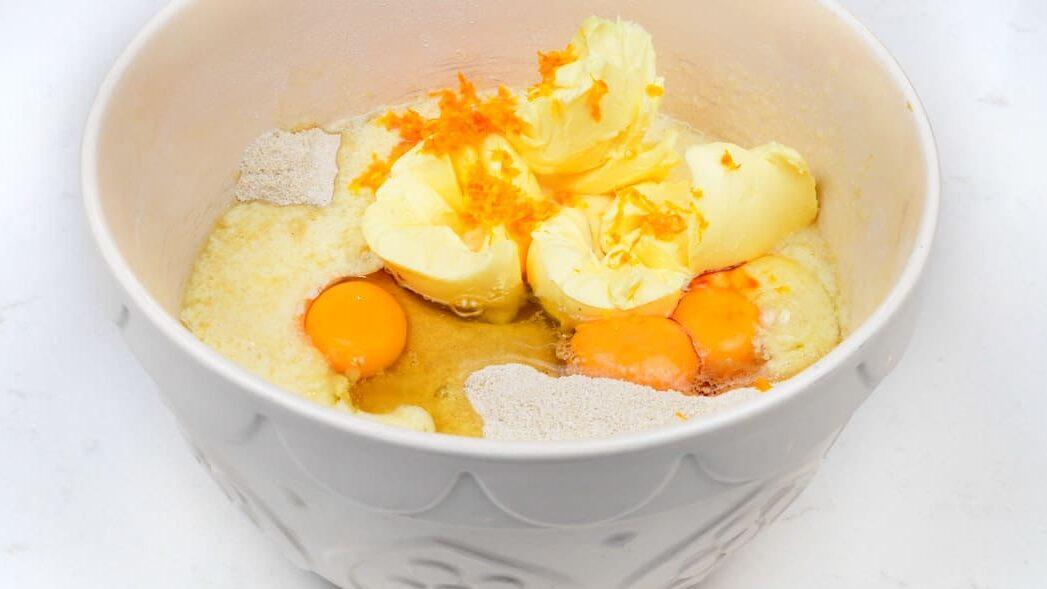 Eggs, butter, sugar, flour and orange zest in a mixing bowl