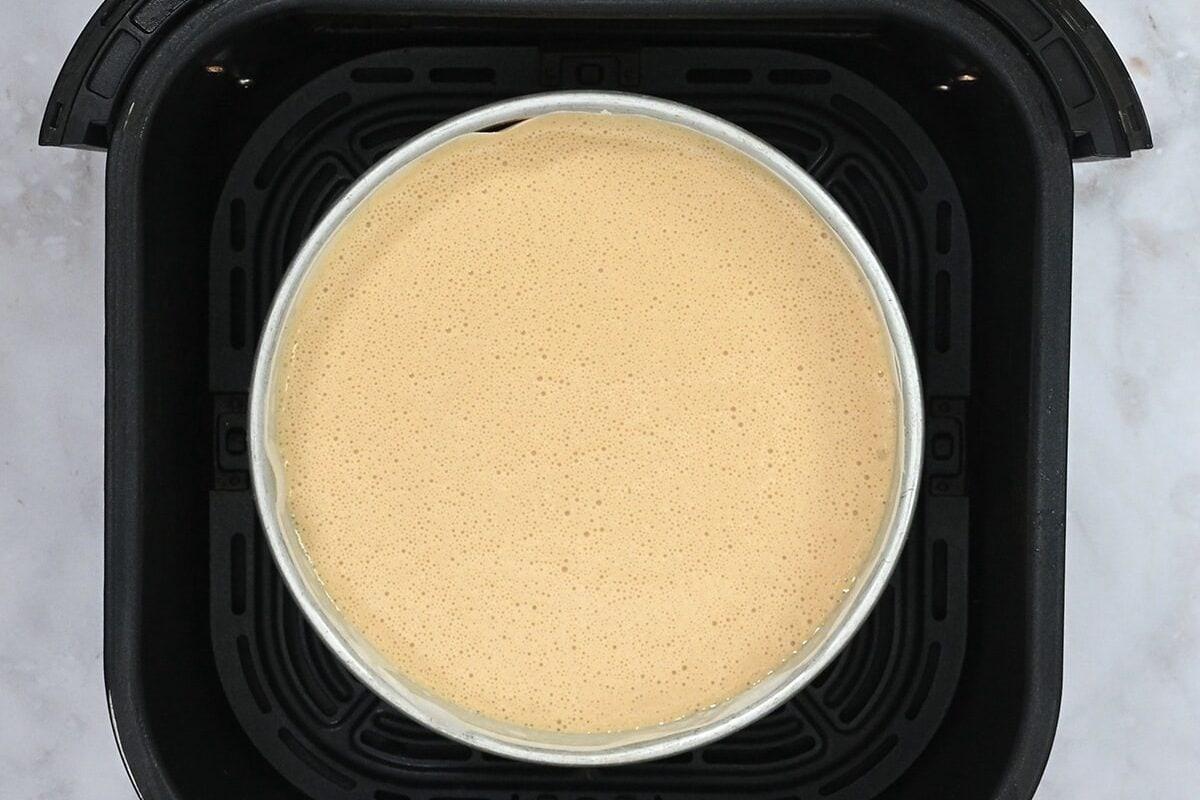 cheesecake in an air fryer basket prior to baking