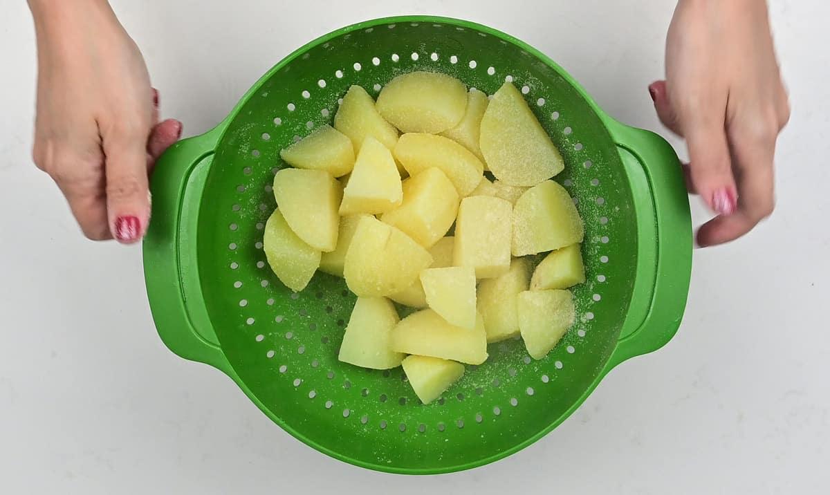 shaking parboiled potatoes in a colander to rough up the edges prior to roasting