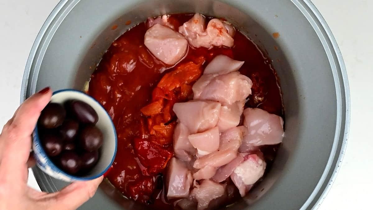 chicken, tomatoes, peppers and olives in a slow cooker