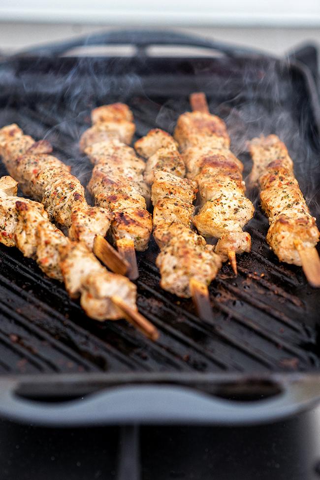 Cooking Greek pork souvlaki (skewers) on a griddle pan
