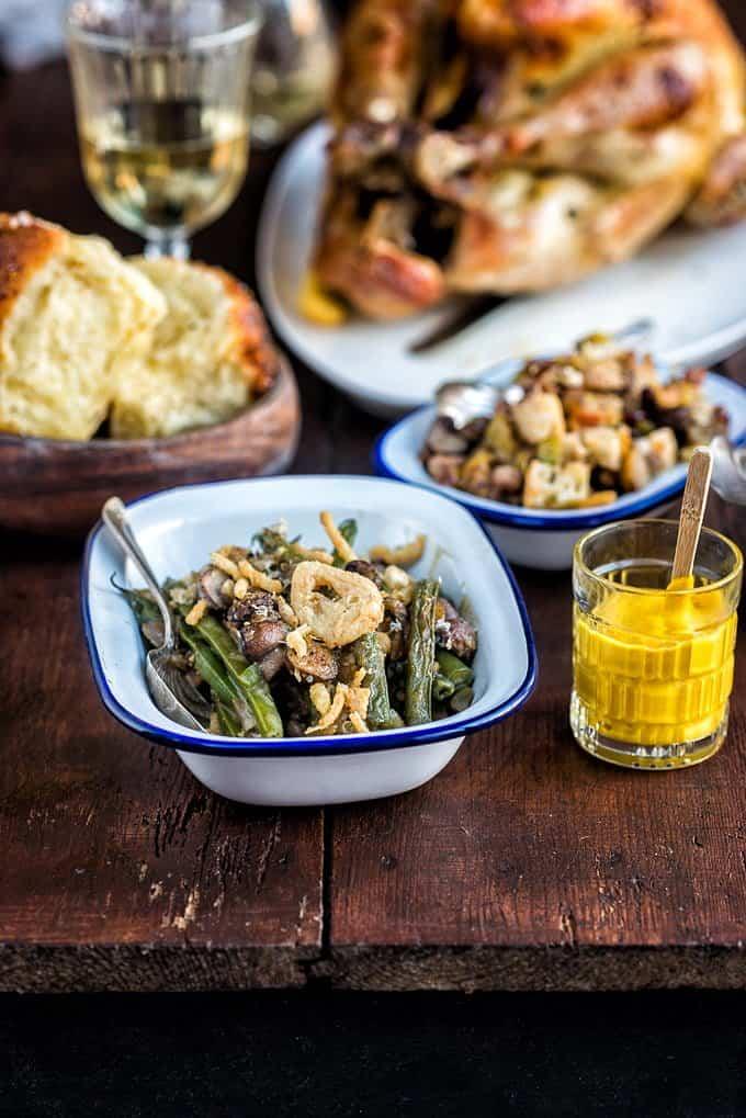 Serving of green bean casserole with turkey and stuffing in the background