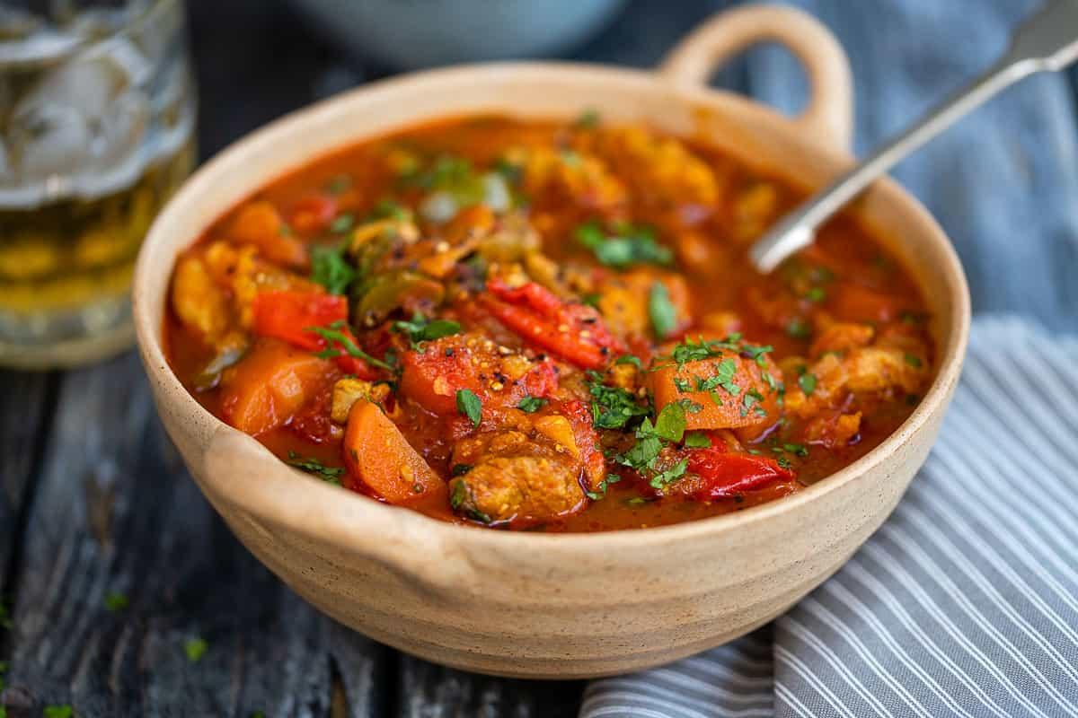 healthy chicken rogan curry in a ceramic bowl garnished with cilantro