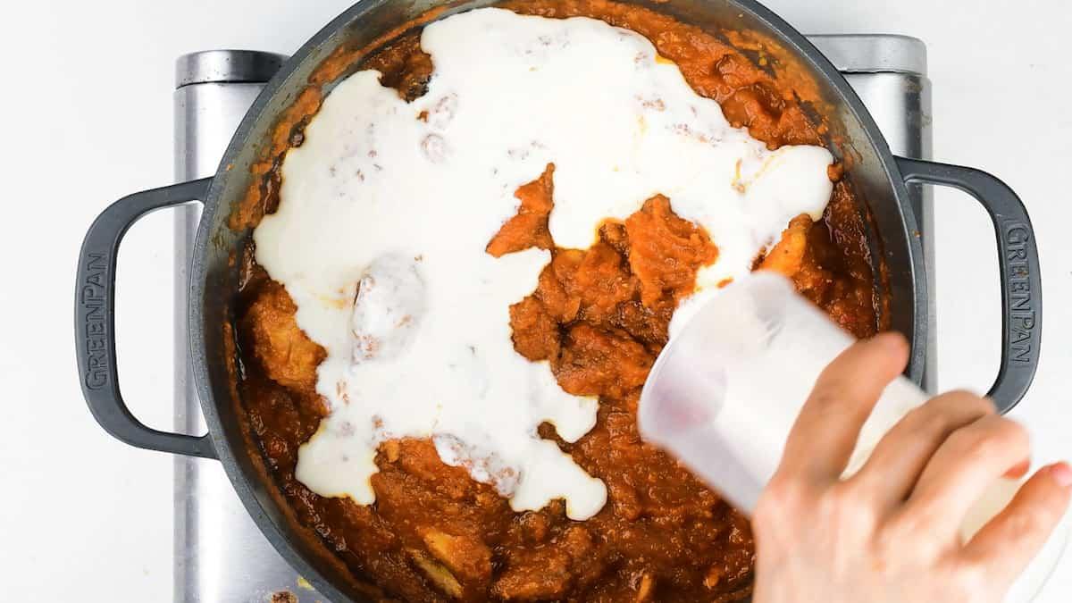 Stirring cream into chicken tikka masala