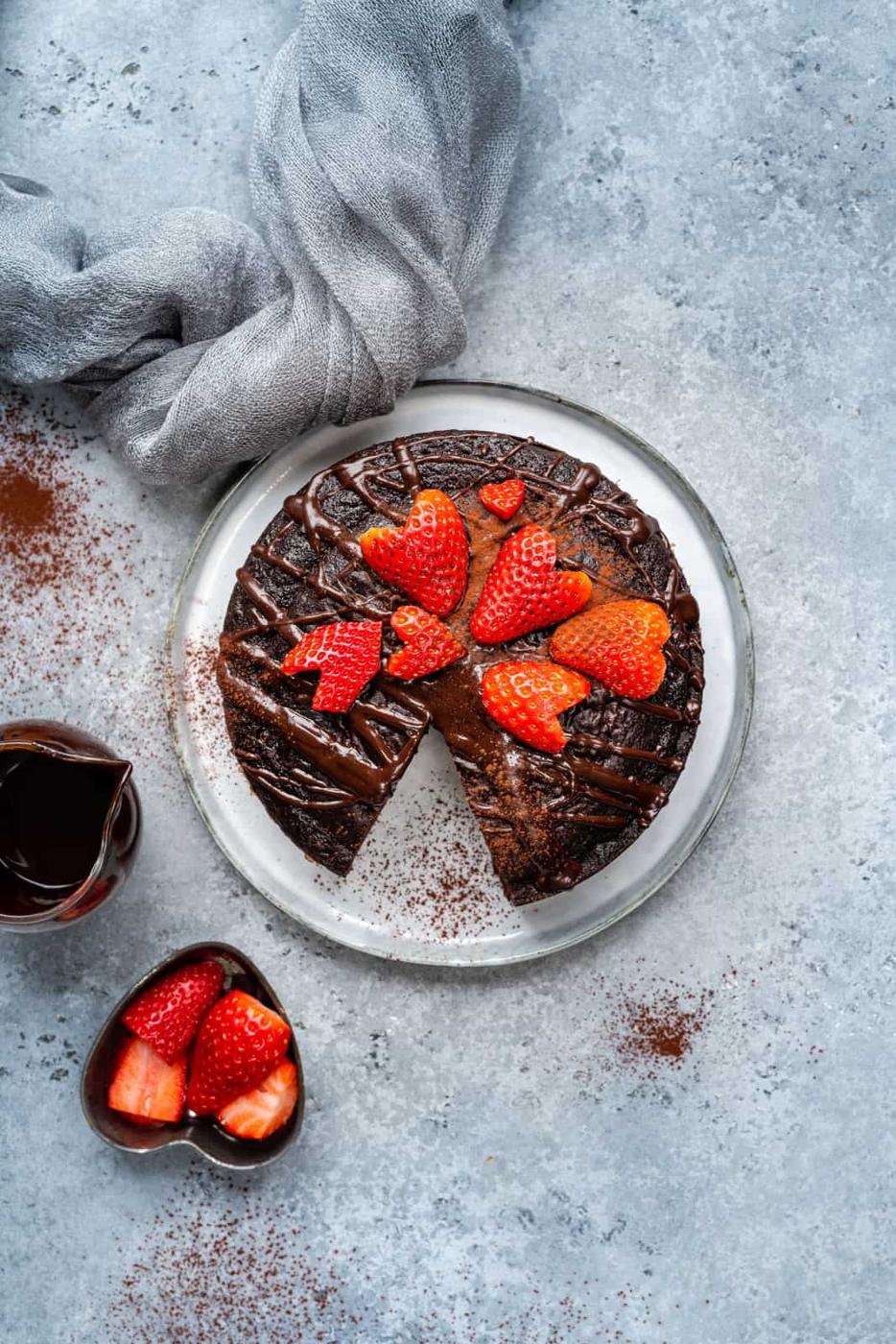 slimming world chocolate cake drizzled with chocolate and decorated with sliced strawberries
