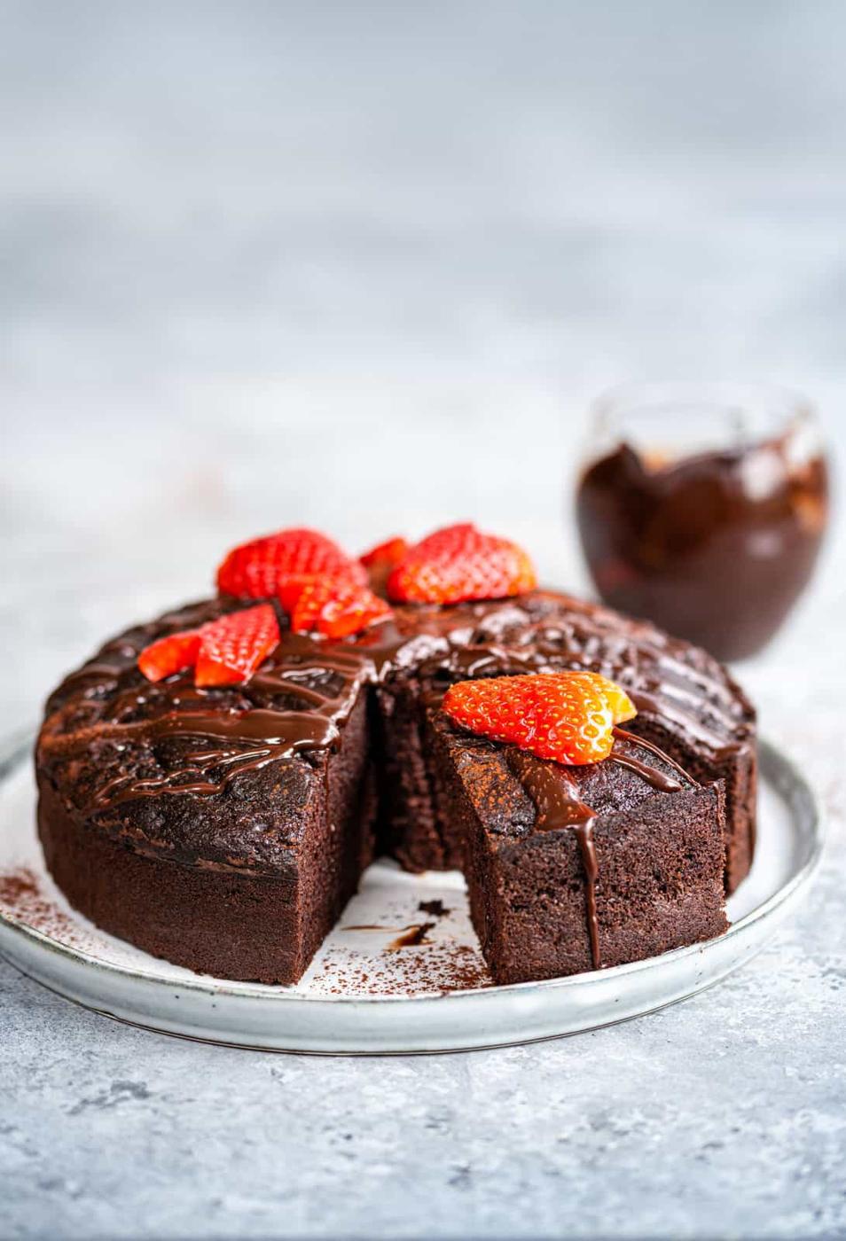 Side view of low fat chocolate cake decorated with fresh strawberries