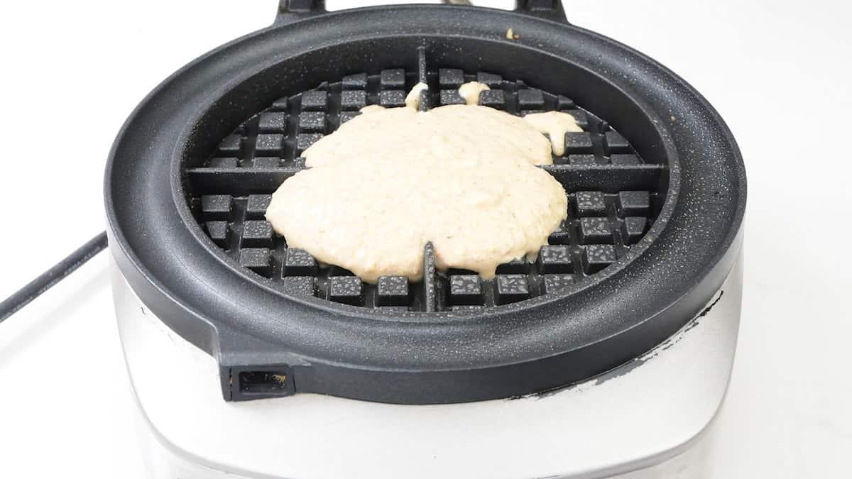 Adding oat waffle batter in a waffle maker