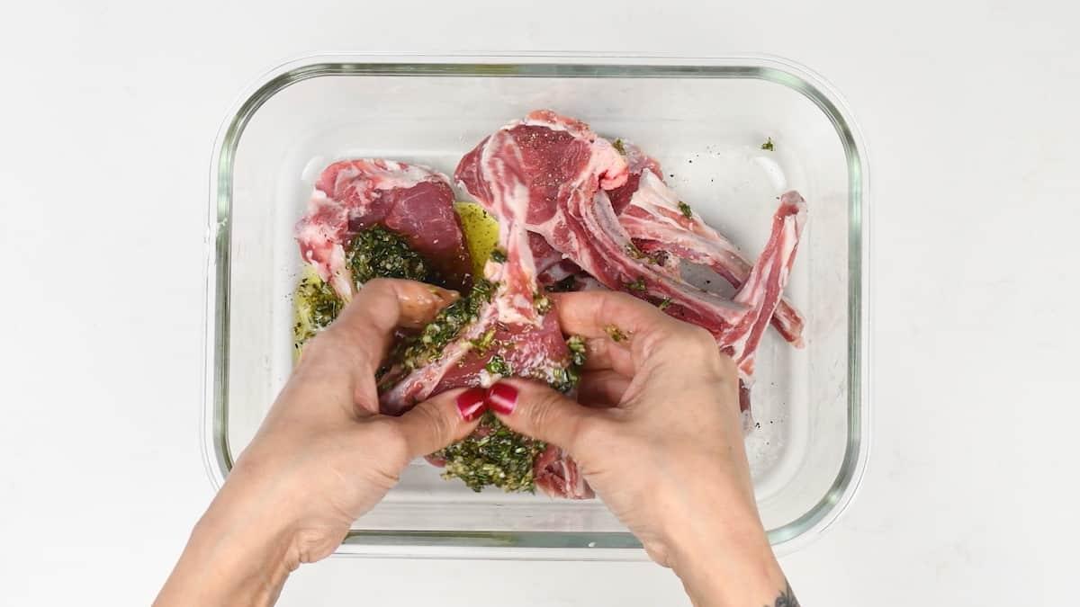 Rubbing herb and garlic marinate into lamb chops