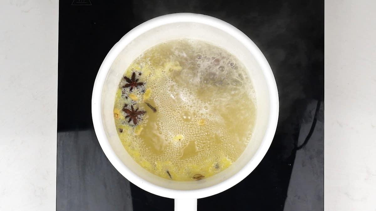 simmering spices and fresh ginger in a saucepan for chai tea